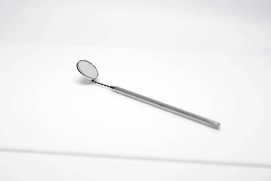 Miroir dentaire utilisé pour examiner une dent avant un traitement canalaire